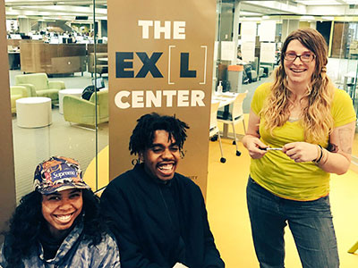 三个学生一起在位于比尔斯图书馆的EXL中心。