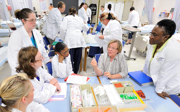 护理专业的学生在实验室里听老师的指导