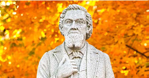 大学的创始人的雕象有秋叶的在背景中