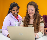 未来的本科生使用笔记本电脑来研究阿克伦大学的学位课程。