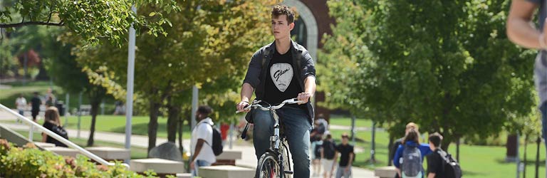 一名学生骑自行车穿过校园中心