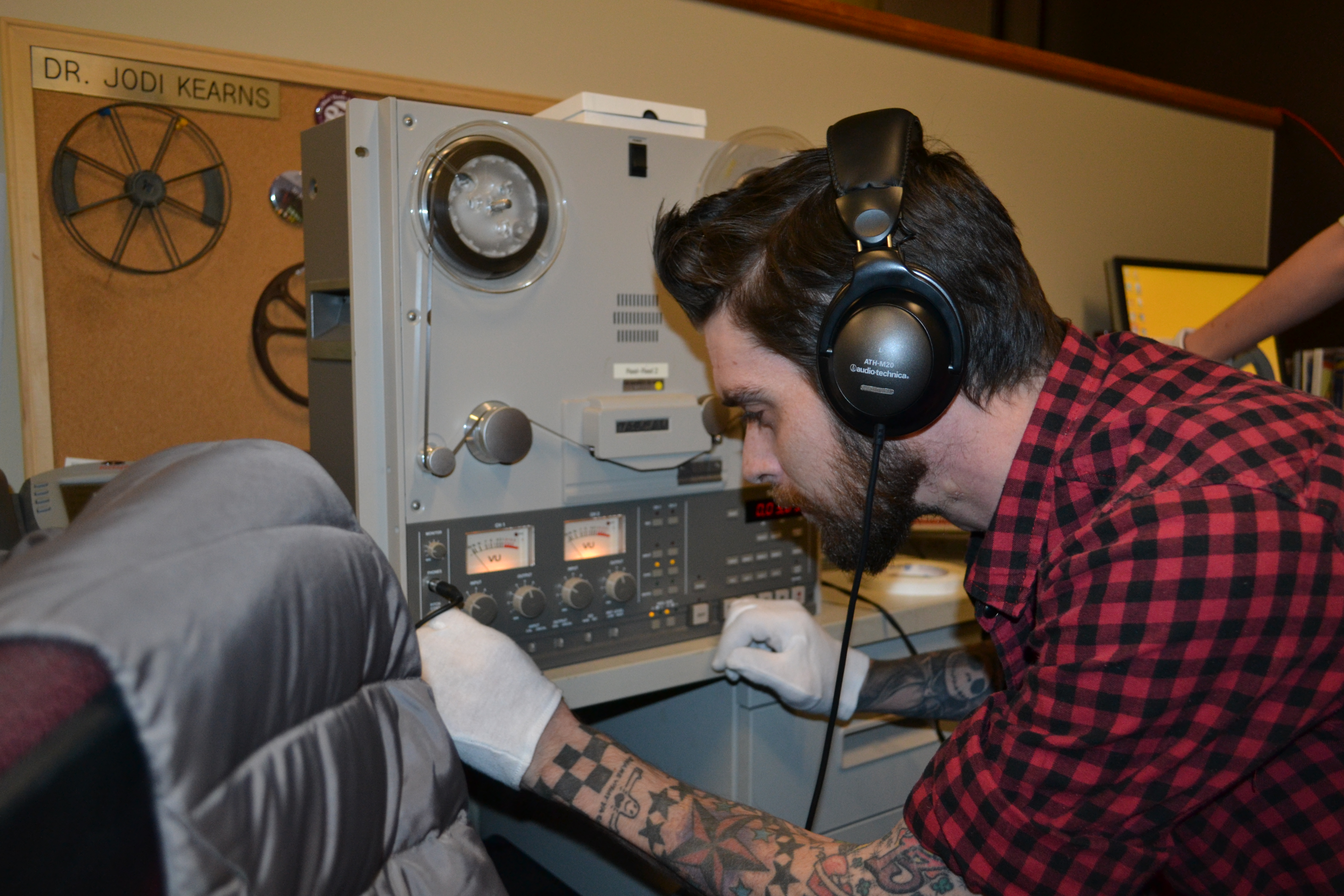 数字媒体专家乔恩·恩德斯戴着耳机检查音频设备