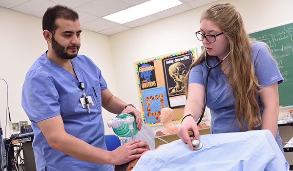 两名护理学生在实验室中一起工作以协助患者。